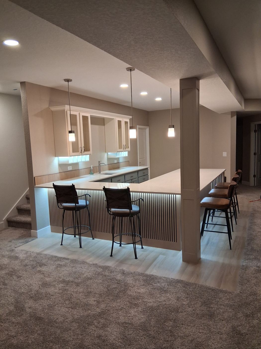 Full basement finish with wraparound bar seating and integrated LED lighting