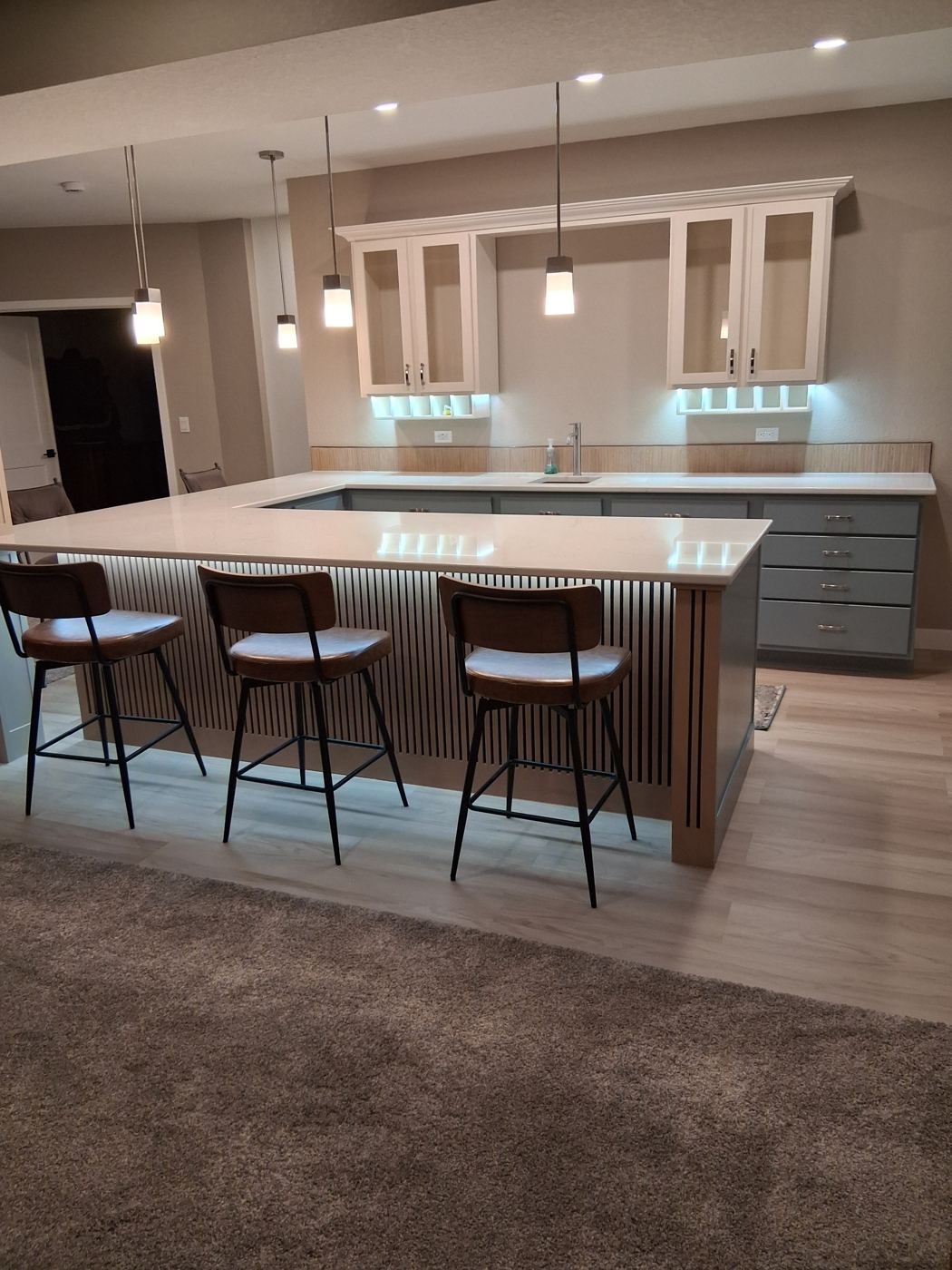 Custom fluted millwork with integrated LED lighting on the bar base