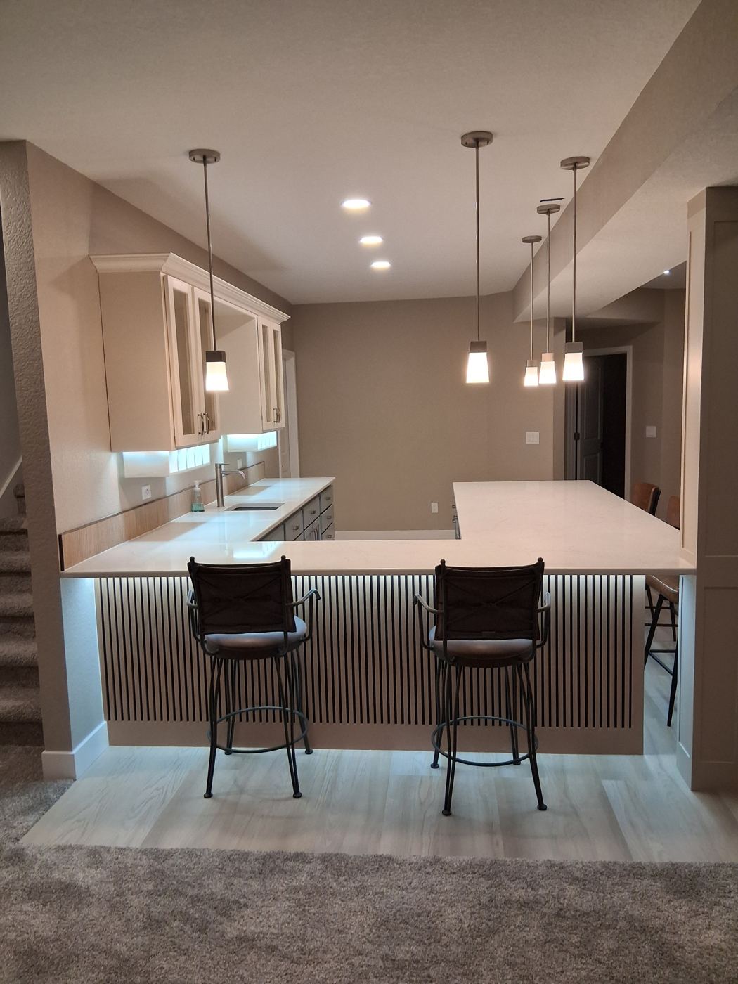Custom wet bar with hand-built slatted bar front and quartz counters, Heritage Todd Creek basement finish